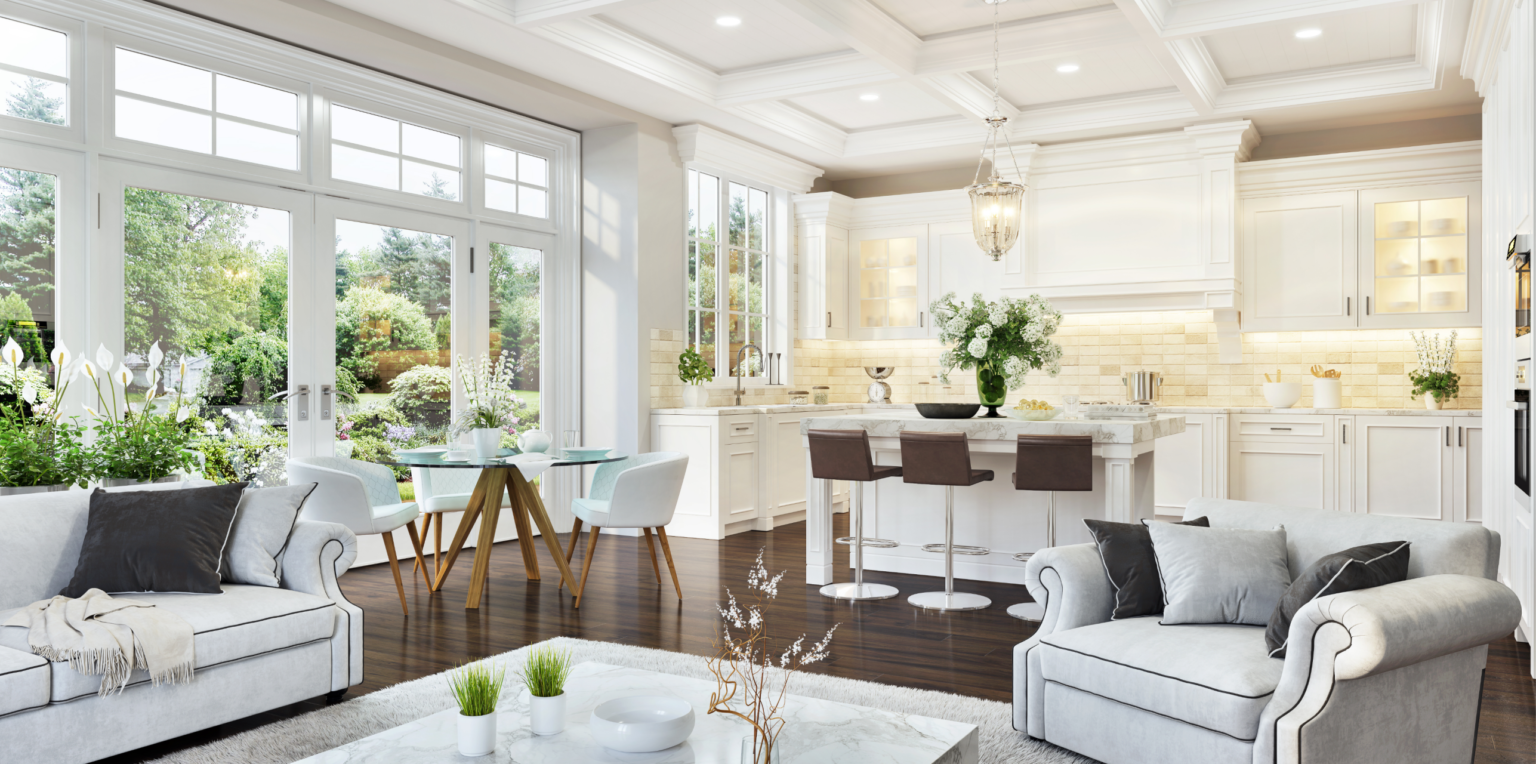 Bright and airy kitchen and living space with large windows opening to a garden. Features white cabinetry, an island with seating, and elegant furniture, creating a sophisticated and inviting environment.